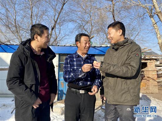 黑龍江省大慶市杜爾伯特蒙古族自治縣一心鄉(xiāng)前進(jìn)村駐村工作隊(duì)隊(duì)長(zhǎng)、第一書(shū)記慕海軍（右）、工作隊(duì)隊(duì)員韓明祥（左）和69歲的脫貧戶楊雙交流（2020年1月4日攝）。新華社記者 楊思琪 攝
